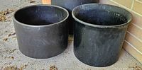 three black patio pots of varying heights and diameters
