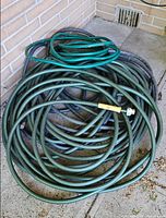 Overview of three coiled hoses against wall
