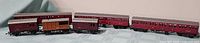 Five maroon coaches and wagon on display