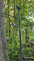 Full view of black metal garden stake with bird silhouette and two hooks