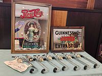 Full lot view: seven Gilcot dispensers and two mirrored bar signs on table