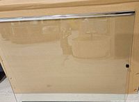 Front view of glass shelf showing chrome-trimmed edge