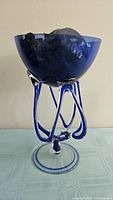 Overall view of blue art glass jellyfish bowl on tentacle stem