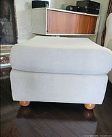 Front view showing fabric, shape, wooden feet