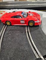Red Porsche 911 GT1 slot car on track
