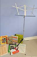 Group view of folding music stand and assorted music books on floor