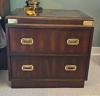 Front view of dark wood night table showing two drawers with brass pulls
