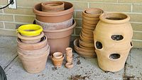 Group view of all clay pots against brick wall