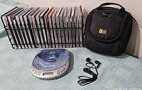 Overall lot showing CD player, earphones, bag, wire rack with CDs