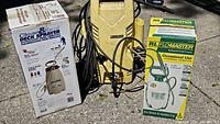 All three items—Karcher washer, Clean & Seal sprayer box, RL Flo-Master sprayer box—on pavement