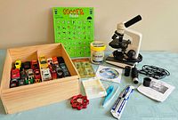Group shot of microscope, cars in box, marbles, puzzle, spinner and accessories