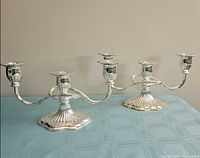 Two silver plated 3-arm candelabras on table