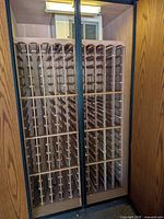 Wine cabinet interior showing wooden bottle racks and cooling unit