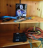 Shelf with Park-Zone box, jumper cables, wiper blades, screwdriver, orange and blue cords, HDX compressor