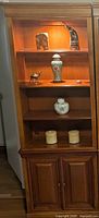 Full view of wood wall unit showing shelves and cupboard