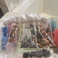 Multiple zip-top bags of assorted beads and findings in satin-lined tray