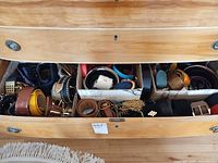 Drawer containing multiple belts stored in three cardboard sections