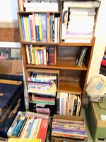 Front view of entire wood veneer bookcase filled with books