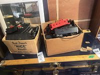 Two boxes containing track sections, transformer and assorted cars