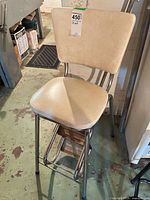 Full view of chrome stool showing vinyl seat/back and integrated fold-up steps