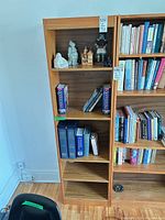 Full view of teak veneer bookcase with five shelves and contents for scale