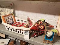 basket with boxed zodiac cups, red wooden firebird mask, framed art edge visible, decorative egg in case