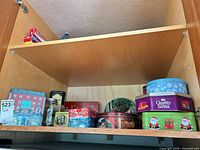 Overall view of tins, mason jar and plate on shelf