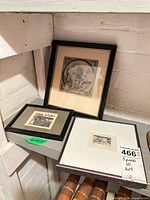 Three framed etchings grouped on shelf