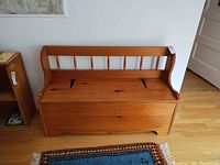 Front view of solid pine storage bench showing spindle backrest and closed lid