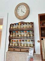 Wall clock and spice rack with jars mounted on wall
