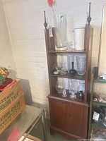 Full view of shelf cabinet showing shelves, finials, and lower cupboard
