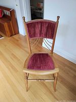 Front view of wooden chair showing upholstery and frame