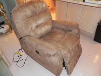 Front and side view of brown leather OKIN power recliner with footrest extended and wired controller visible.