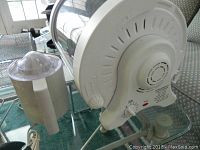 George Foreman Rotisserie GR826 back, showing power cord and part of accessories on glass surface.