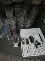 Clear acrylic tumblers and pitcher with stainless steel flatware in white tray