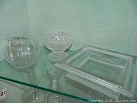 Three crystal bowls displayed: ribbed Baccarat bowl, etched Lalique square footed bowl, and a cut crystal footed candy bowl.