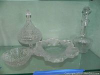 Overview of all four glass and crystal pieces on shelf