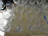 Photo showing several crystal wine glasses with starburst etched design arranged closely on a surface.