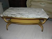 Full view of Italian marble coffee table showing two-tiered design, marble top, and gold metal legs with lion head details in corners.