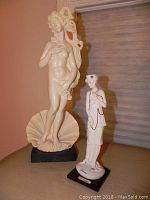 Photo showing both statuettes side by side: the large Venus in the Half Shell and the smaller 1920s woman figurine.