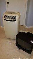 Royal Sovereign portable air conditioner, front view with vents and control panel visible, along with the MGA CRT TV beside it.
