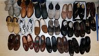 Overview of the 22 pairs of men's shoes in various styles and brands, laid out on the floor.