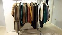 Clothing rack with over 30 men's jackets and coats in various materials and colors.