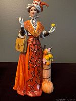 Front view of porcelain Mrs. Albee figurine with barrel and pumpkin