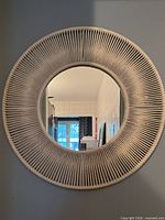 Front view of the round wall mirror showing full cord-wrapped sunburst frame and central glass
