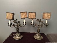 Both wrought iron candelabra lamps with four shades visible