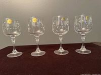 Four etched Princess House wine glasses side by side