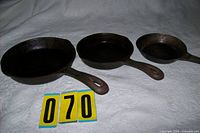 Three skillets side by side showing size differences and handles