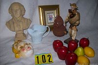 Group shot of entire lot showing bust, pitcher, figurines, mask head, fabric horse head, framed print and artificial fruit