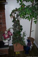 Tall artificial ficus tree, vine topiary, two floral arrangements grouped